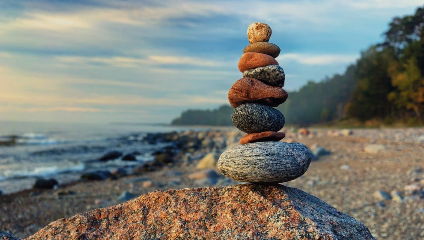 A cairn of balanced stones on a lake shore