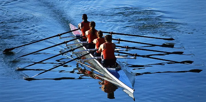 A rowing crew pulling together on open water